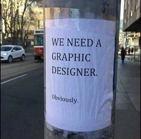 foglio di carta attaccato ad un palo con su scritto:"we need a graphic designer. obviously"