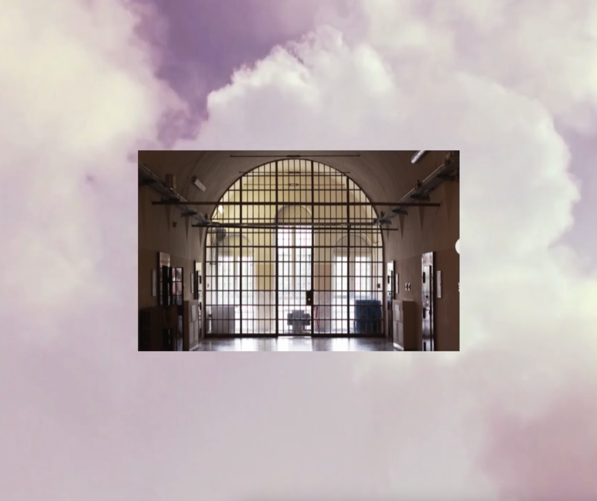 sullo sfondo un cielo nuvoloso, in primo piano una foto dall'interno del carcere